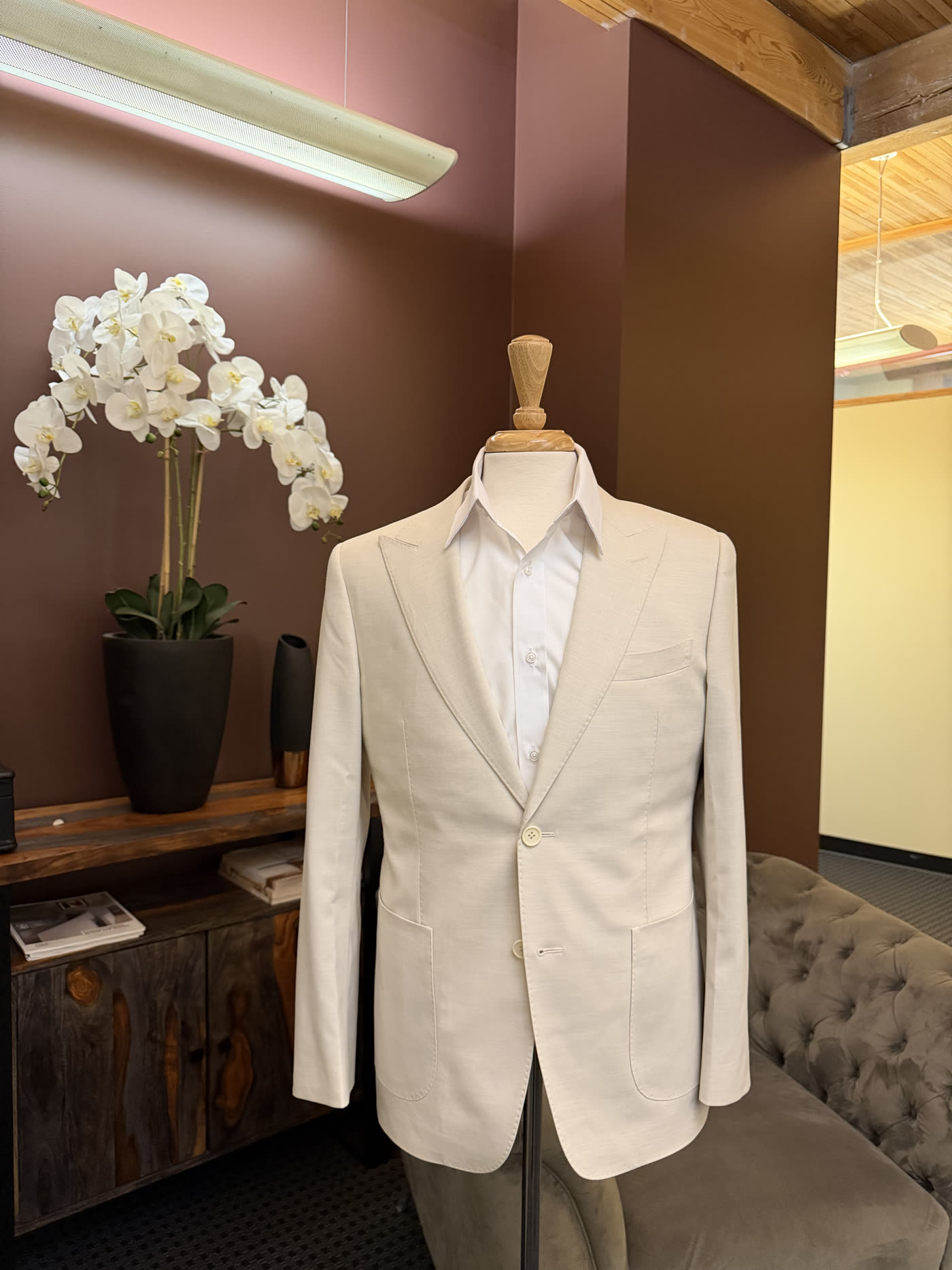 A Conxeppt custom cream dinner jacket on the form in the atelier