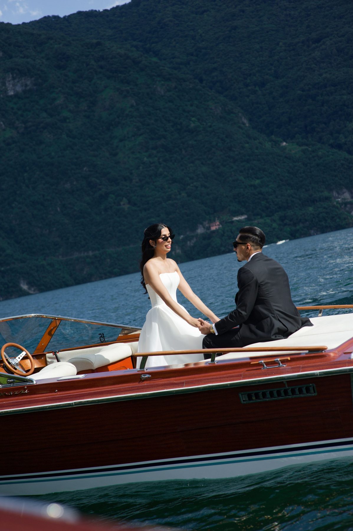 The bride and groom aboard a wooden Riva boat on Lake Como