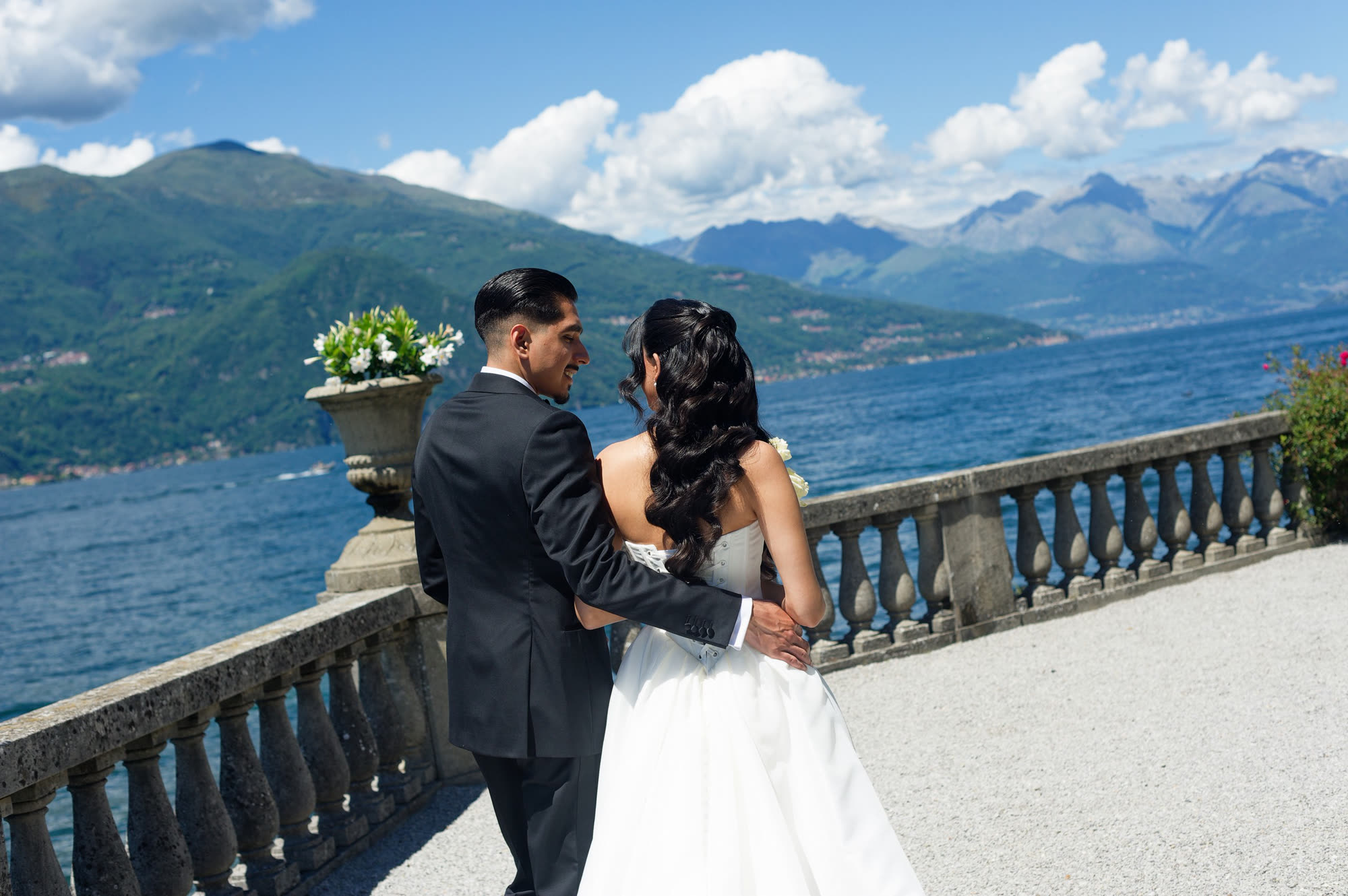 A groom in a Conxeppt custom black tuxedo on the terrace at Lake Como